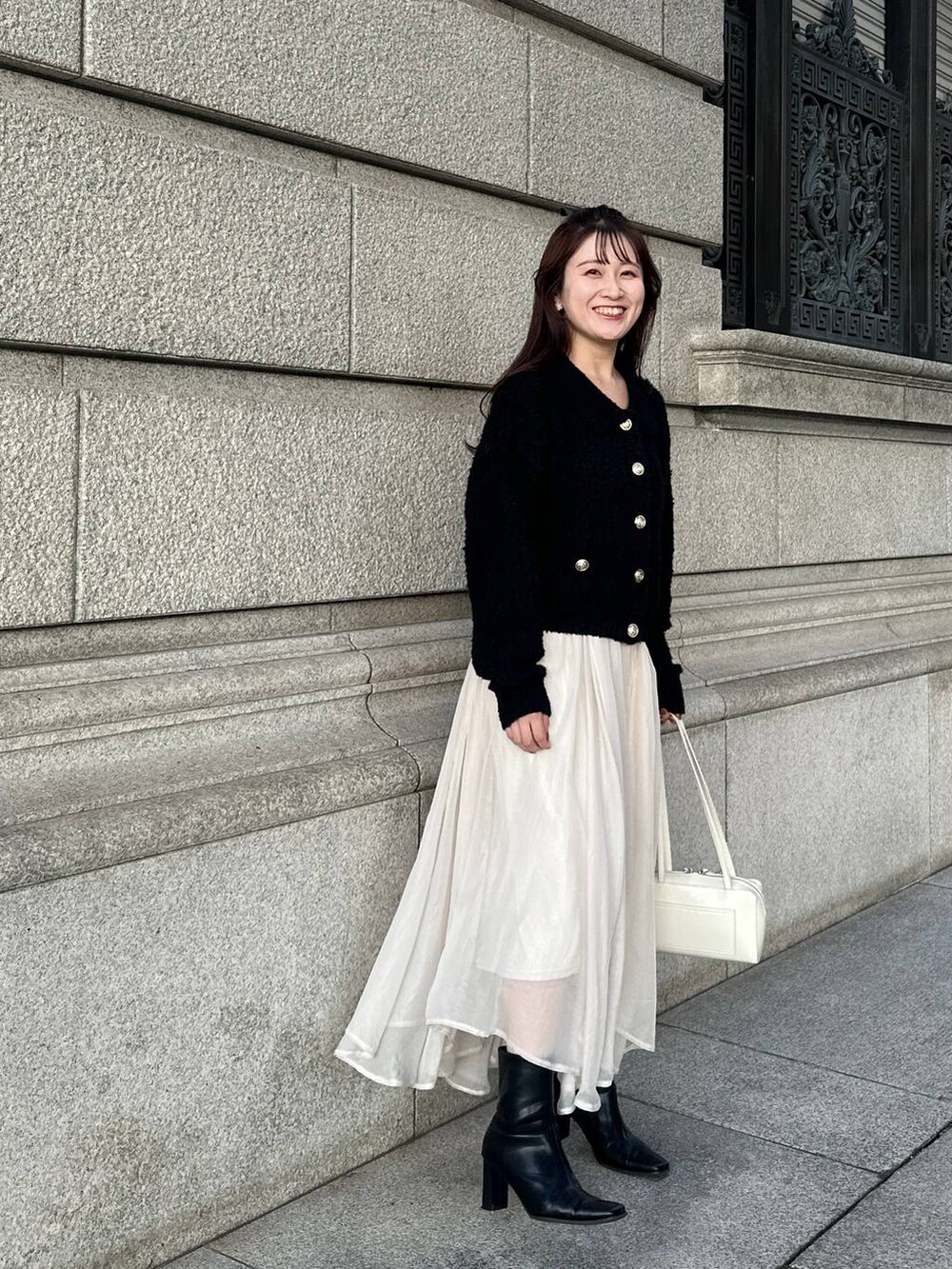 ブラック系のカーディガン/ボレロ、ホワイト系のスカートを着用したレディースの秋コーディネートの3枚目の写真