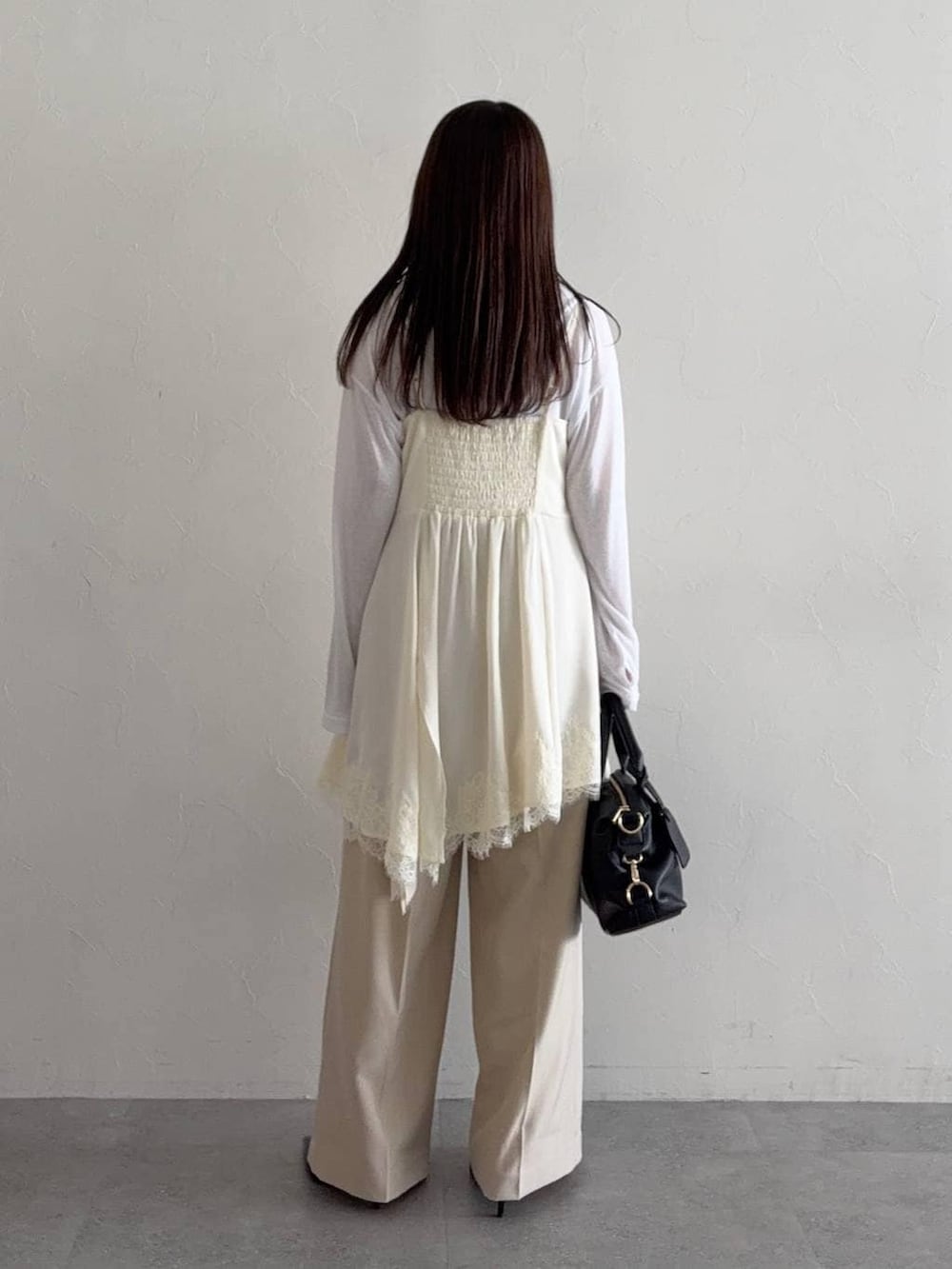 ホワイト系のTシャツ/カットソー、ブラック系のボストンバッグ、ブルー系のデニムジャケットを着用したレディースの冬コーディネートの4枚目の写真