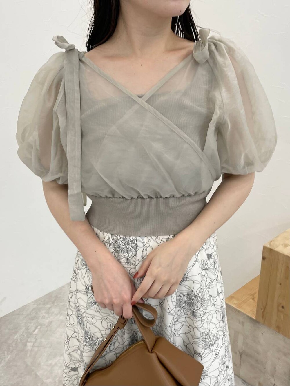 ブラウン系のショルダーバッグ、ホワイト系のスカート、ホワイト系のサンダルを着用したレディースの夏コーディネートの3枚目の写真