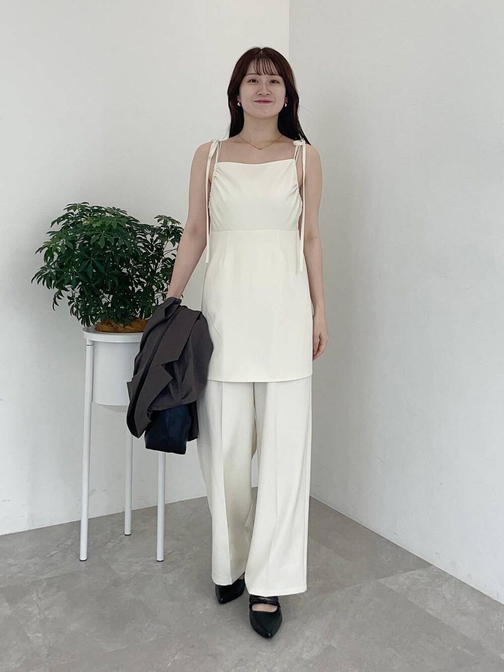 ブラウン系のテーラードジャケット、ブラック系のショルダーバッグ、ブラック系のパンプスを着用したレディースの夏コーディネートの3枚目の写真