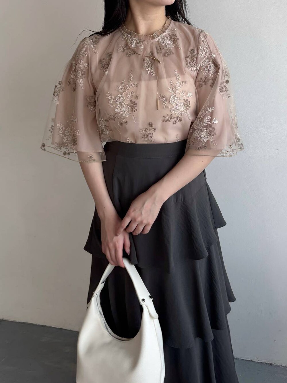 グレー系のスカート、シルバー系のバレエシューズ、ピンク系のシャツ/ブラウスを着用したレディースの春コーディネートの3枚目の写真