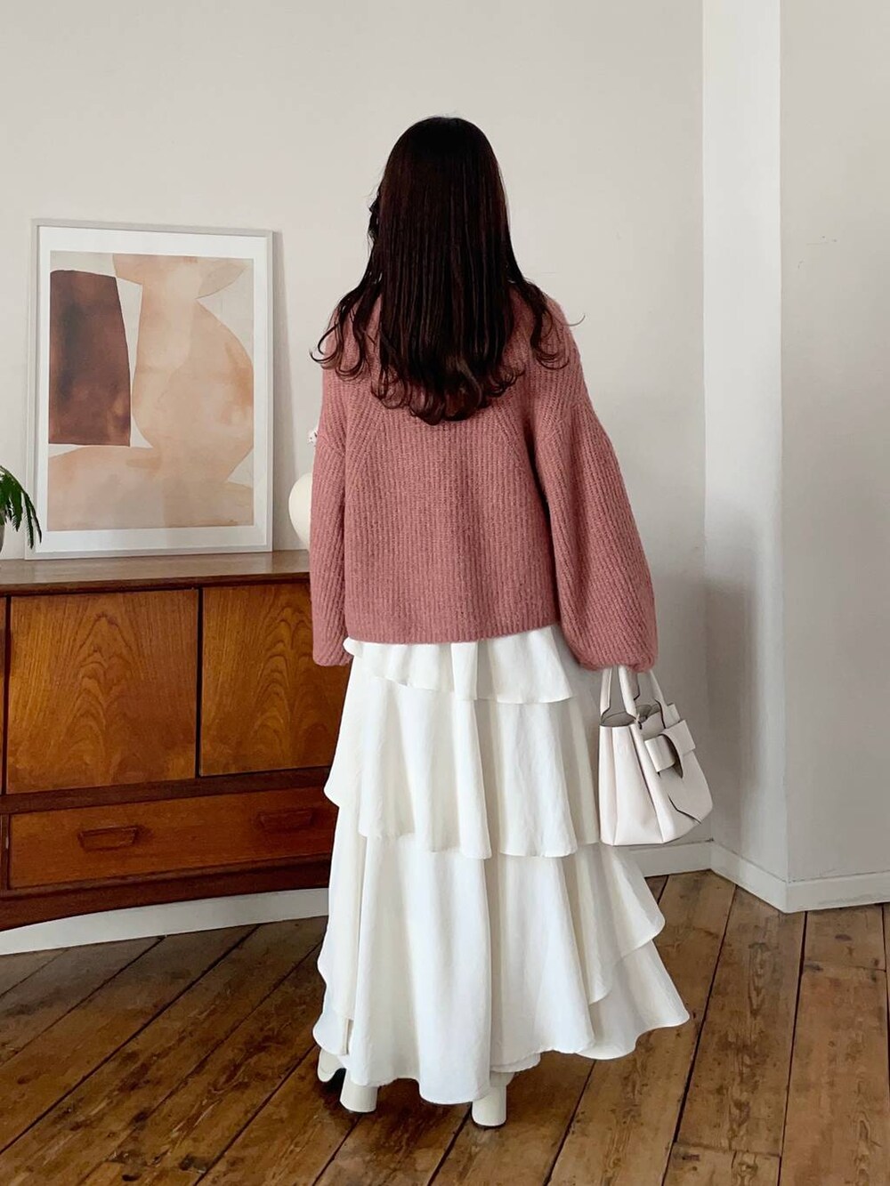 ホワイト系のチェスターコート、ホワイト系のブーツ、ホワイト系のスカートを着用したレディースの冬コーディネートの4枚目の写真