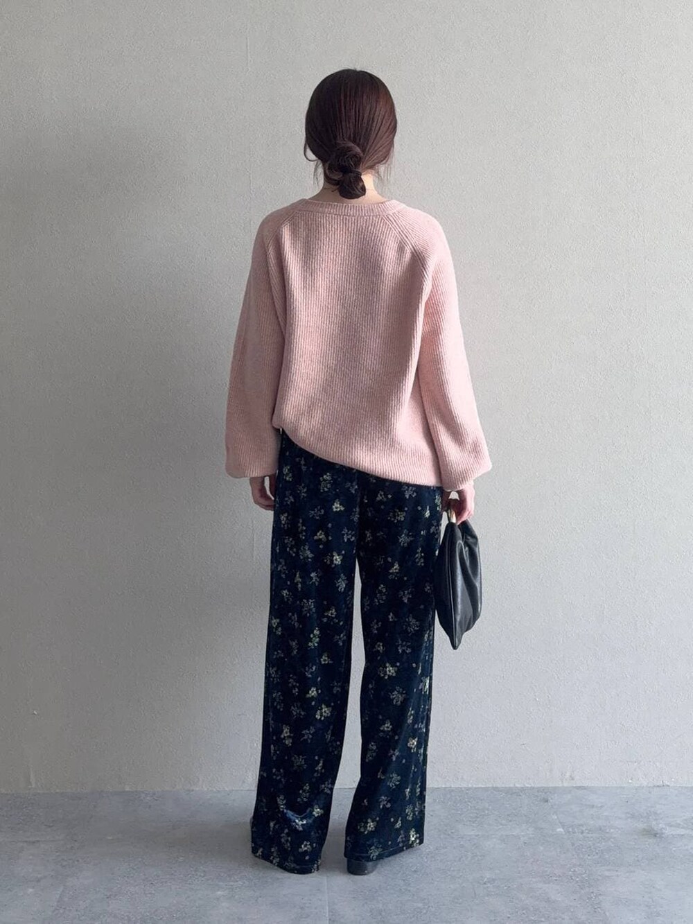 ブラック系のハンドバッグ、ピンク系のニット/セーター、ブラック系のローファーを着用したレディースの冬コーディネートの2枚目の写真