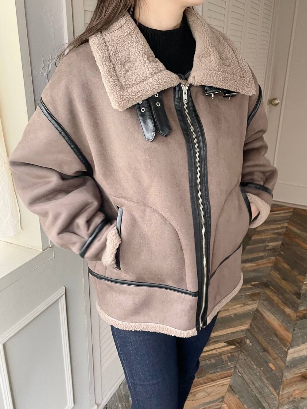 ブルー系のデニムパンツ、ブラウン系のハンドバッグ、ブラック系のブーツを着用したレディースの秋コーディネートの5枚目の写真