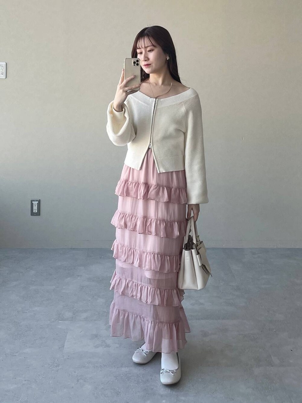 ホワイト系のショルダーバッグ、シルバー系のバレエシューズ、ピンク系のスカートを着用したレディースの春コーディネートの3枚目の写真