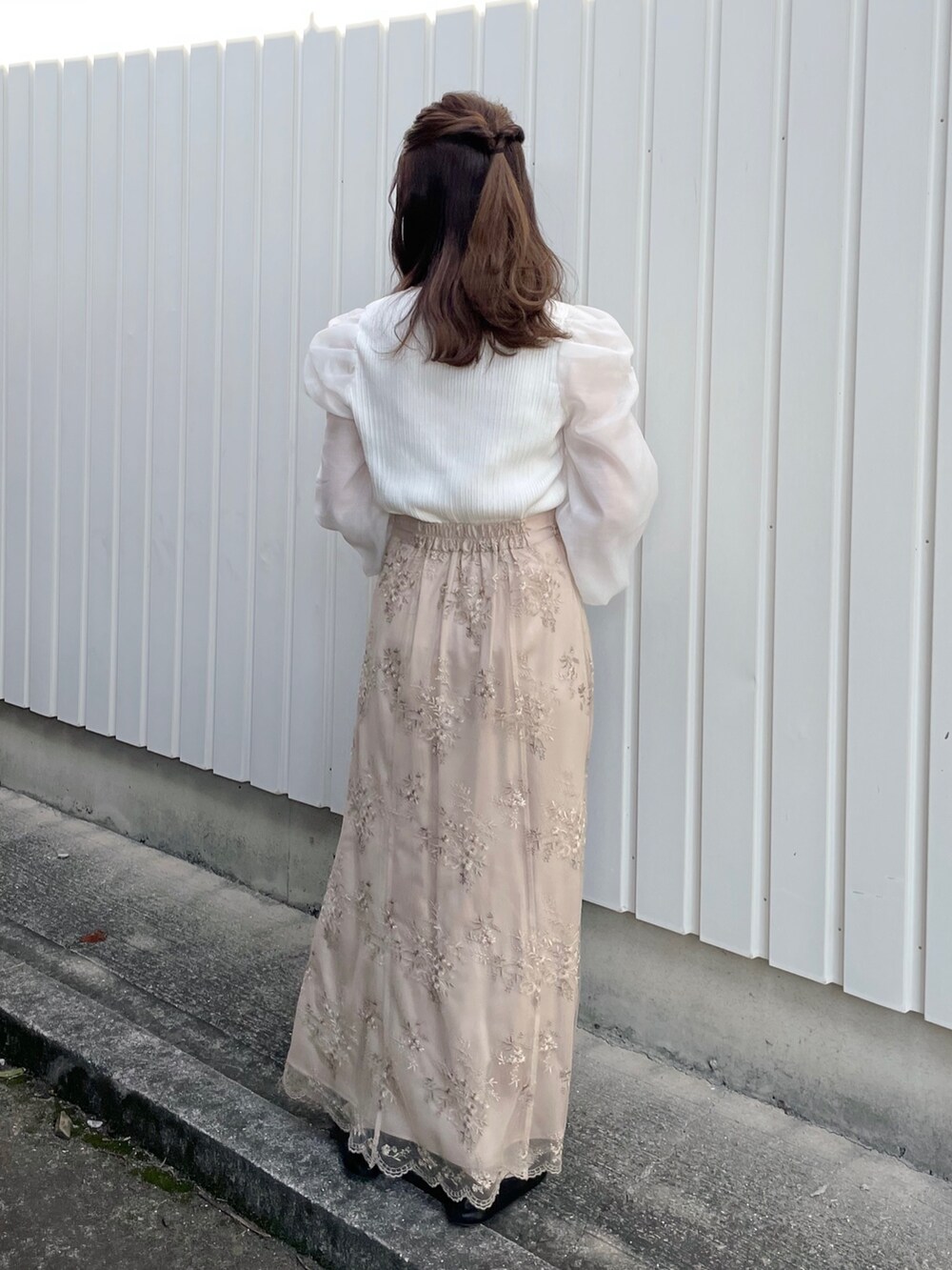 ホワイト系のカーディガン/ボレロ、ブラウン系のスカートを着用したレディースの冬コーディネートの2枚目の写真