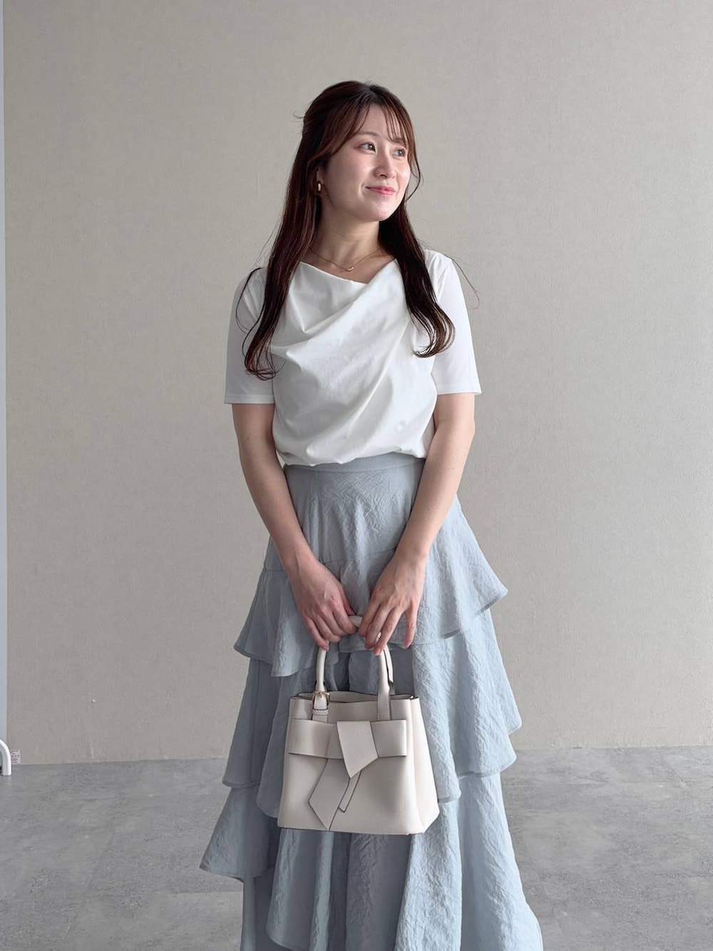ホワイト系のTシャツ/カットソー、ホワイト系のショルダーバッグ、グレー系のスカートを着用したレディースの夏コーディネートの3枚目の写真