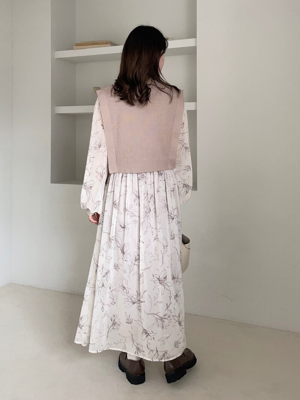 ホワイト系のワンピース、ホワイト系のバッグ、ブラウン系のローファーを着用したレディースの冬コーディネートの2枚目の写真