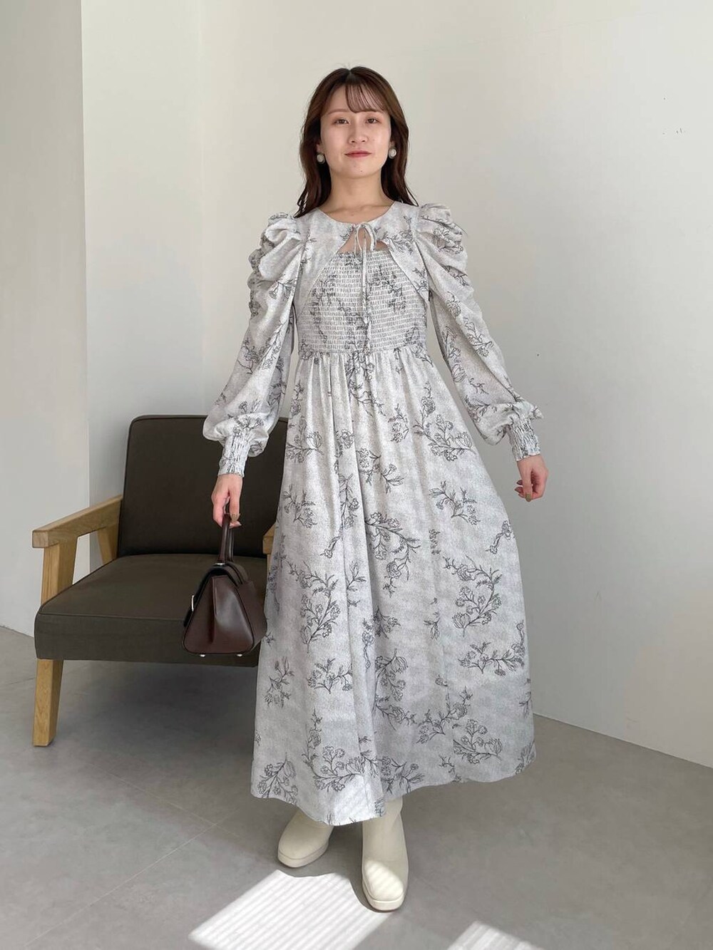 ブラウン系のハンドバッグ、ホワイト系のブーツ、ブラウン系のカーディガン/ボレロを着用したレディースの秋コーディネートの5枚目の写真