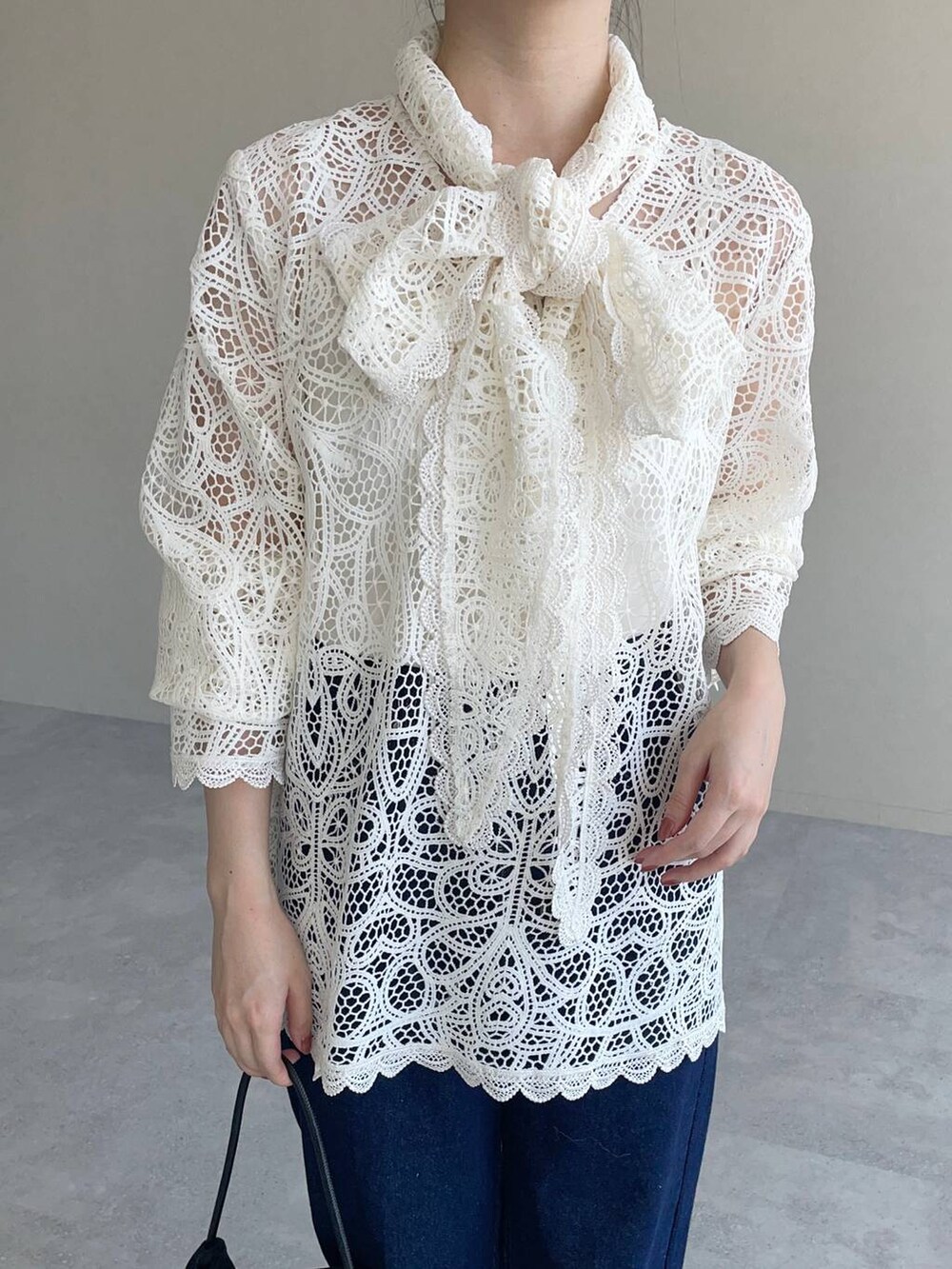 ホワイト系のシャツ/ブラウス、ブルー系のデニムパンツ、ブラック系のパンプスを着用したレディースの秋コーディネートの3枚目の写真