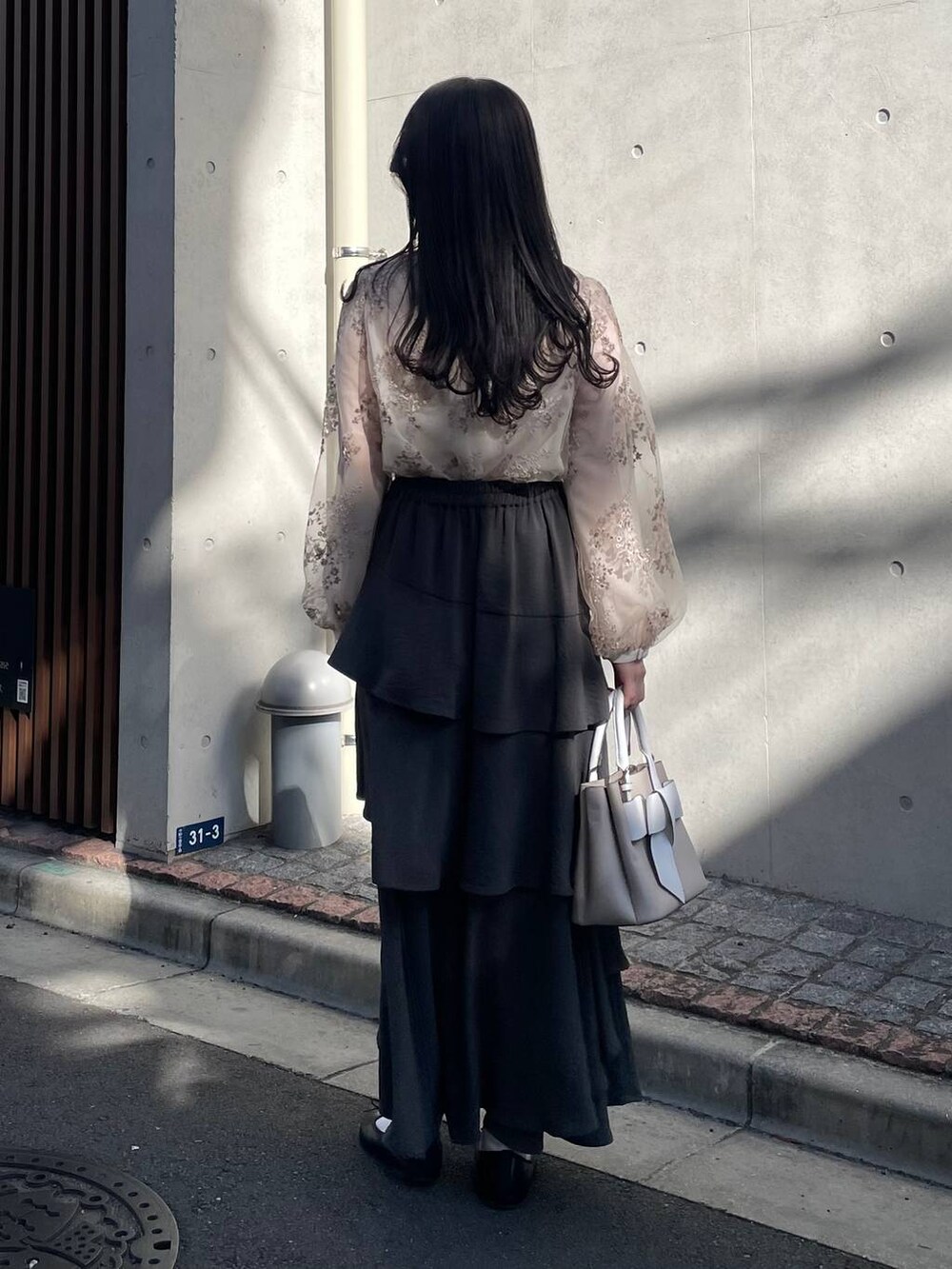 ホワイト系のシャツ/ブラウス、グレー系のスカート、ベージュ系のショルダーバッグを着用したレディースの春コーディネートの2枚目の写真