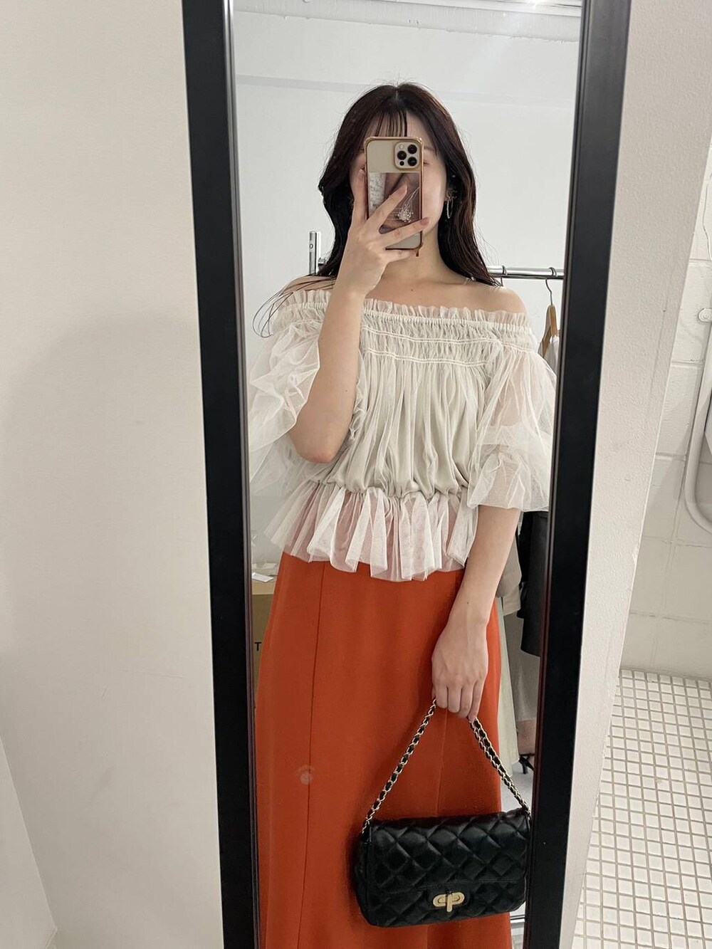 ブラック系のパンプス、ホワイト系のシャツ/ブラウス、ブラック系のショルダーバッグを着用したレディースの夏コーディネートの3枚目の写真