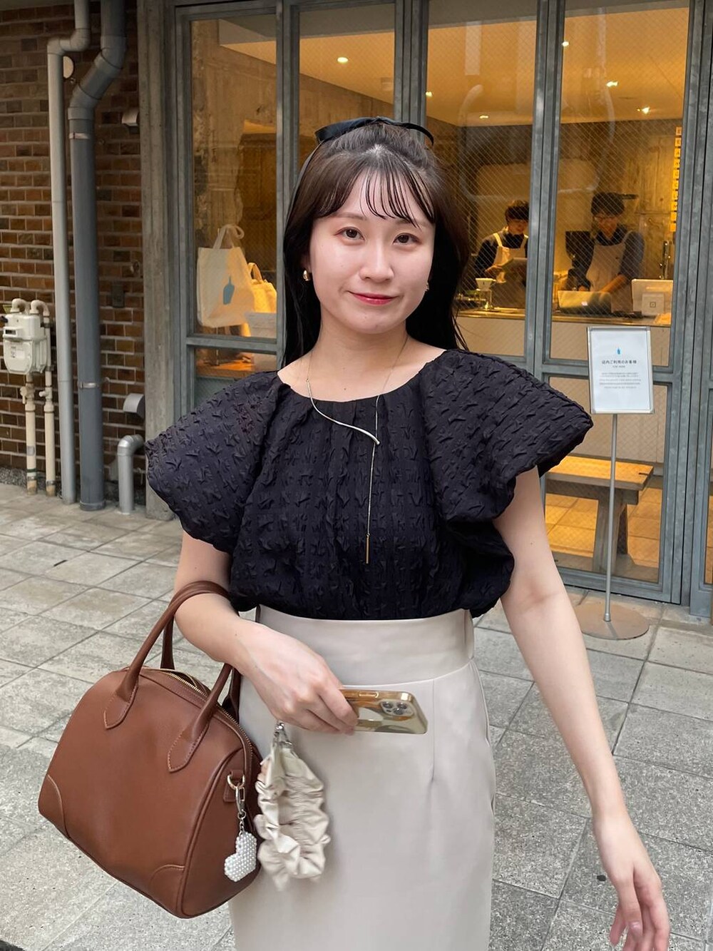 ブラウン系のショルダーバッグ、ブラック系のシャツ/ブラウス、ベージュ系のキーホルダーを着用したレディースの秋コーディネートの3枚目の写真