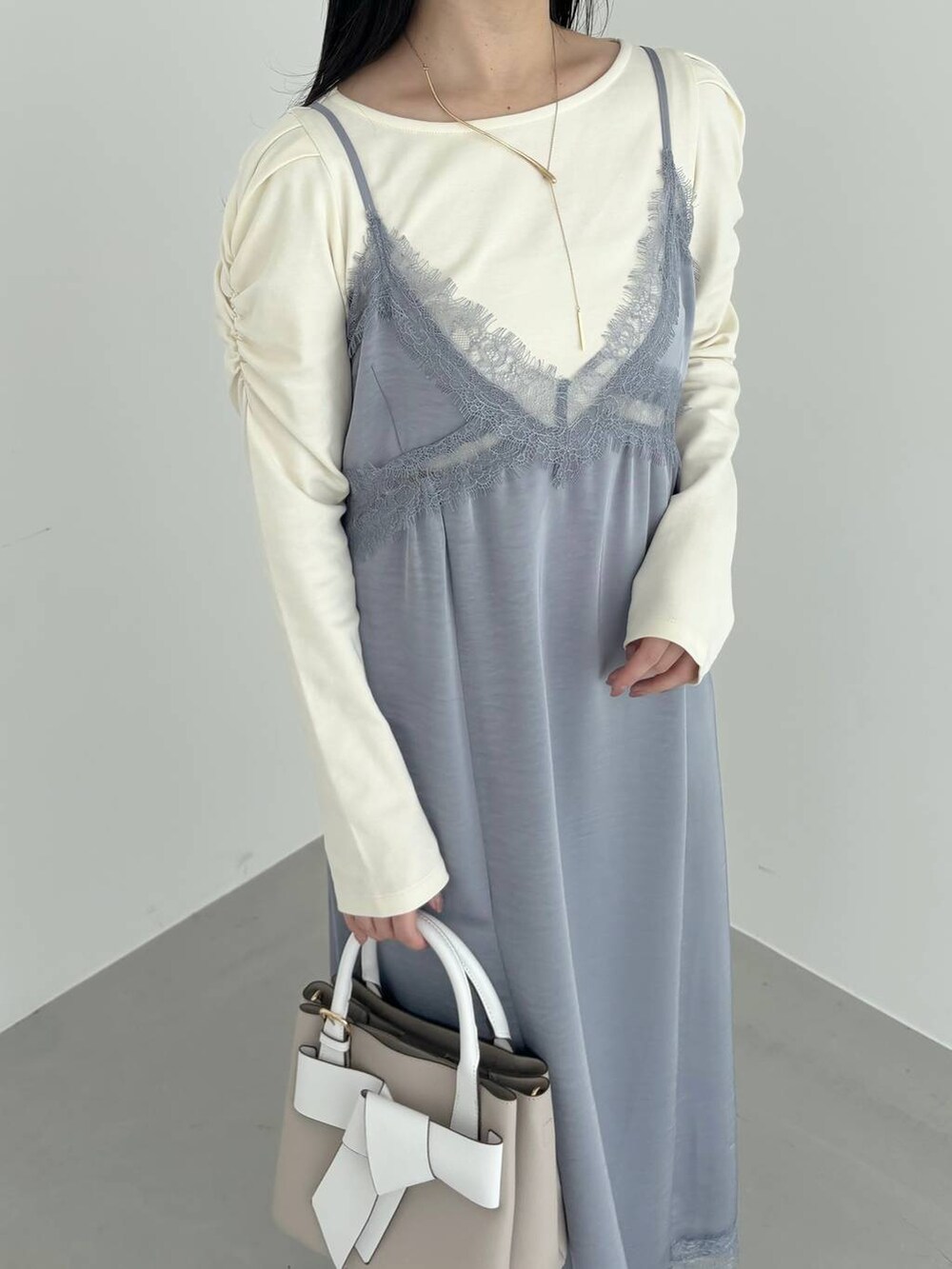 ベージュ系のショルダーバッグ、ホワイト系のマウンテンパーカー、シルバー系のバレエシューズを着用したレディースの春コーディネートの7枚目の写真