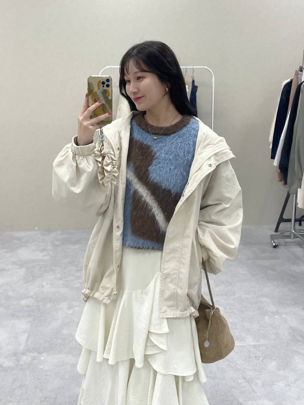 ブラウン系のニット/セーター、ホワイト系のスカート、ブラック系のローファーを着用したレディースの秋コーディネートの2枚目の写真