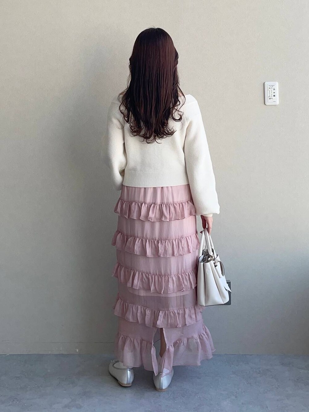 ホワイト系のショルダーバッグ、シルバー系のバレエシューズ、ピンク系のスカートを着用したレディースの春コーディネートの2枚目の写真