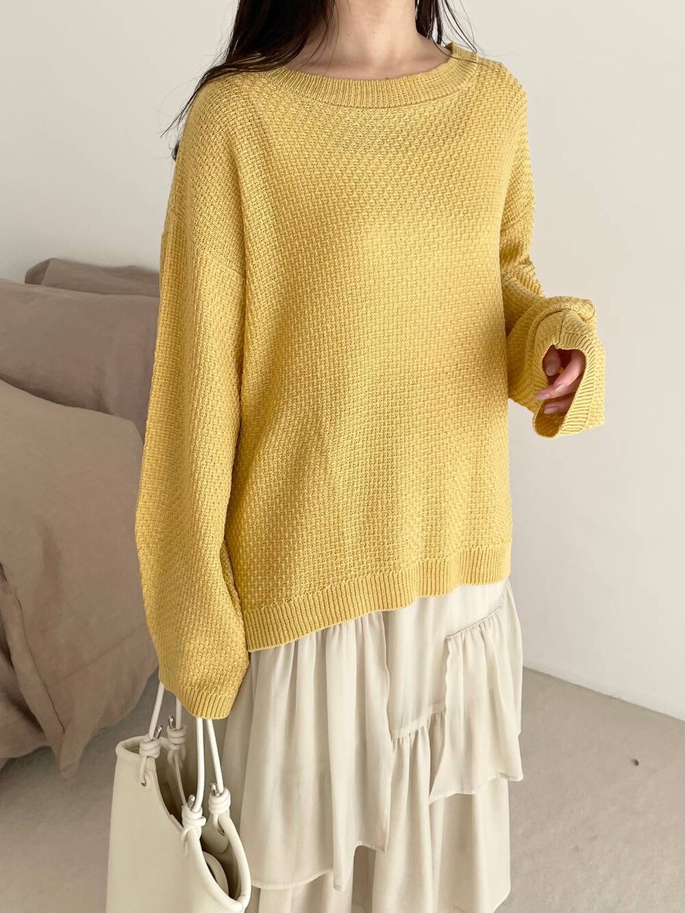 ホワイト系のスカート、イエロー系のTシャツ/カットソー、ホワイト系のブーツを着用したレディースの春コーディネートの3枚目の写真