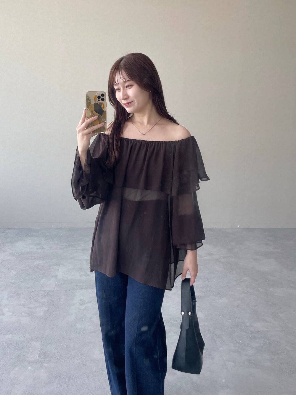 ブラック系のショルダーバッグ、ブラウン系のシャツ/ブラウス、ブルー系のデニムパンツを着用したレディースの夏コーディネートの3枚目の写真