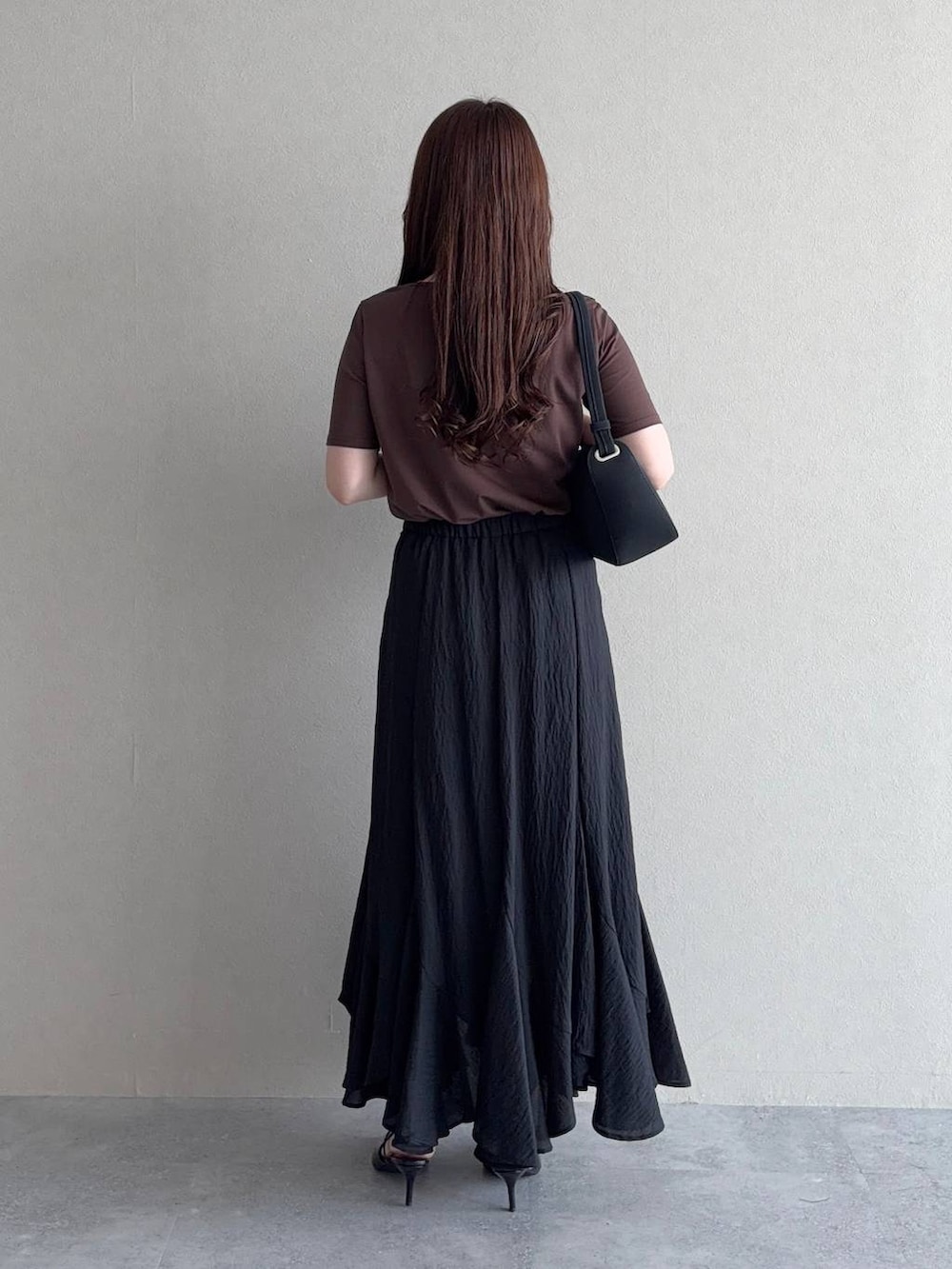 ブラウン系のTシャツ/カットソー、ブラック系のサンダル、ブラック系のスカートを着用したレディースの夏コーディネートの2枚目の写真
