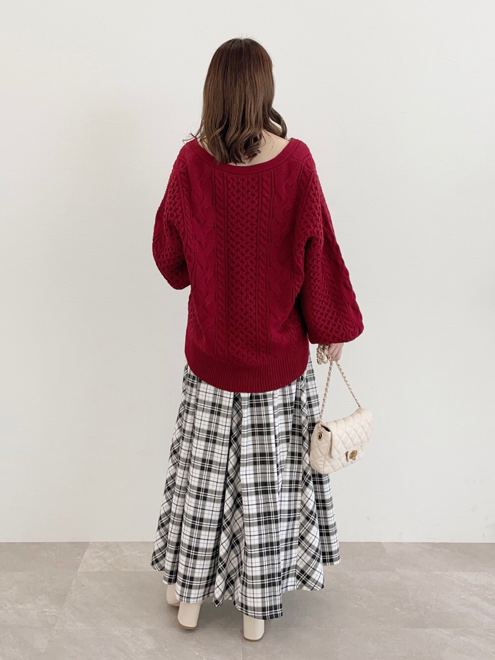 レッド系のカーディガン/ボレロ、ホワイト系のタンクトップ、ホワイト系のスカートを着用したレディースの秋コーディネートの2枚目の写真