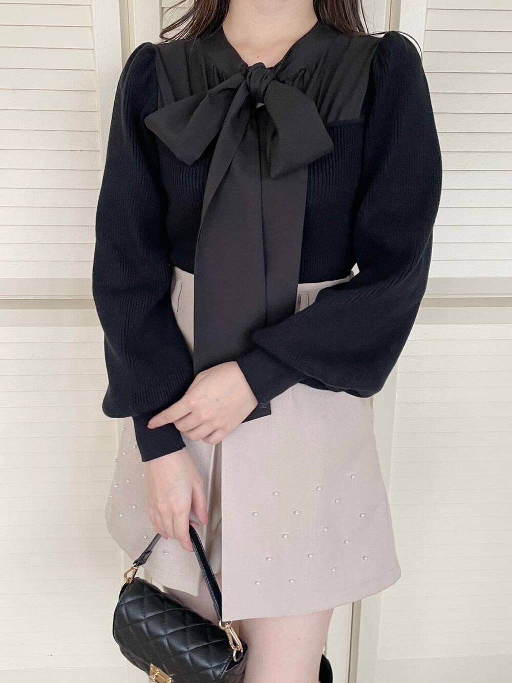 グレー系のノーカラーコート、ブラック系のブーツ、ブラック系のニット/セーターを着用したレディースの秋コーディネートの6枚目の写真