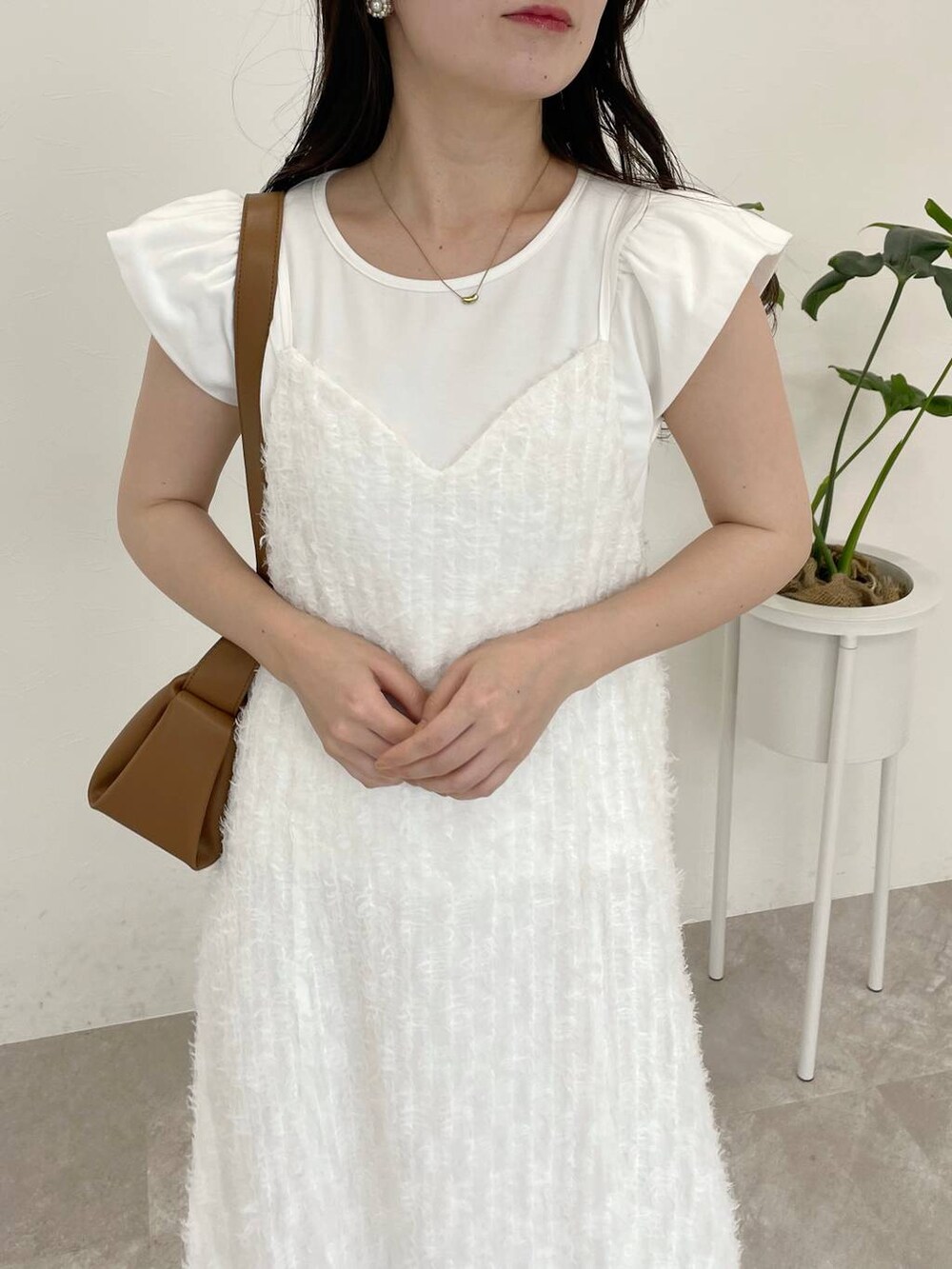 ホワイト系のワンピース、ホワイト系のTシャツ/カットソー、ブラウン系のショルダーバッグを着用したレディースの春コーディネートの3枚目の写真
