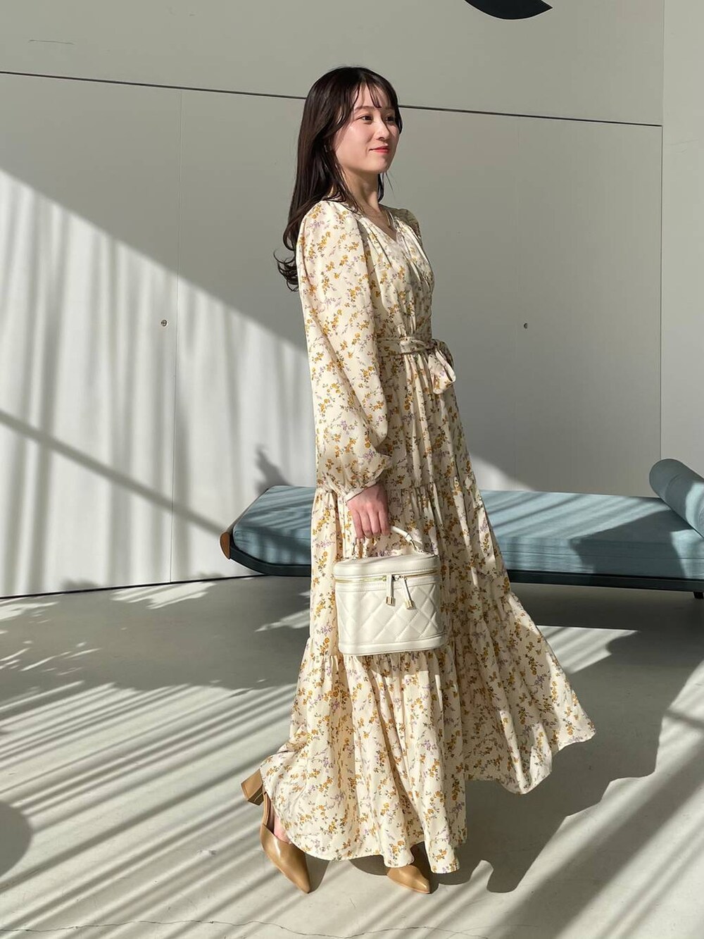 ホワイト系のタンクトップ、ホワイト系のショルダーバッグ、ベージュ系のパンプスを着用したレディースの冬コーディネートの2枚目の写真