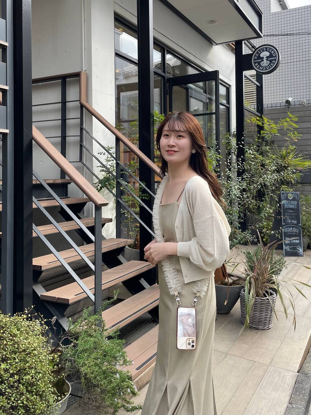 ブラウン系のショルダーバッグ、ホワイト系のカーディガン/ボレロ、ベージュ系のワンピースを着用したレディースの夏コーディネートの3枚目の写真