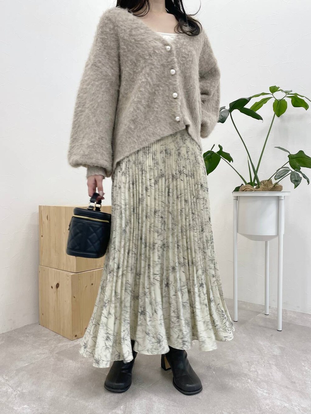 ホワイト系のタンクトップ、グレー系のブーツ、ブラウン系のカーディガン/ボレロを着用したレディースの冬コーディネートの4枚目の写真