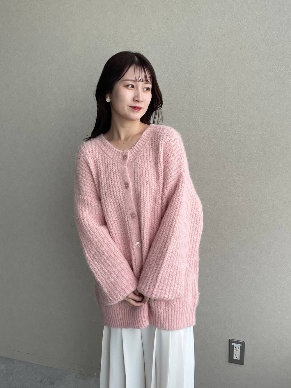 ブラウン系のブーツ、ピンク系のカーディガン/ボレロ、ブラウン系のハンドバッグを着用したレディースの秋コーディネートの6枚目の写真