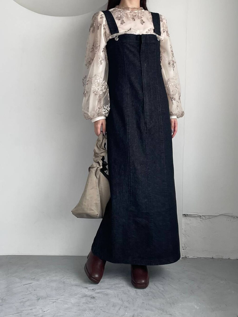 ホワイト系のシャツ/ブラウス、ブラック系のジャンパースカート、ブラウン系のブーツを着用したレディースの夏コーディネートの3枚目の写真