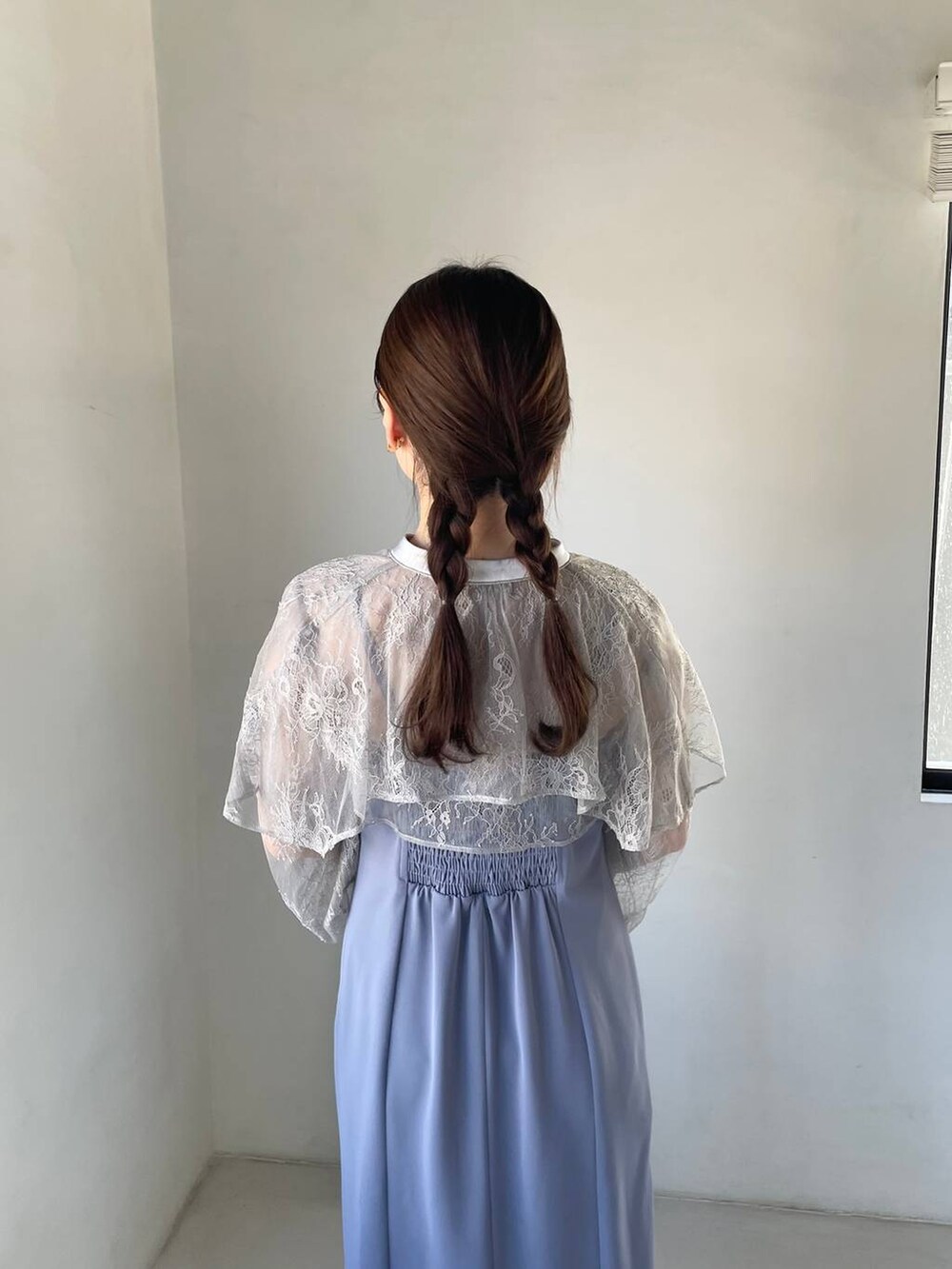 ブルー系のドレス、ホワイト系のショルダーバッグ、ブラック系のパンプスを着用したレディースの冬コーディネートの5枚目の写真