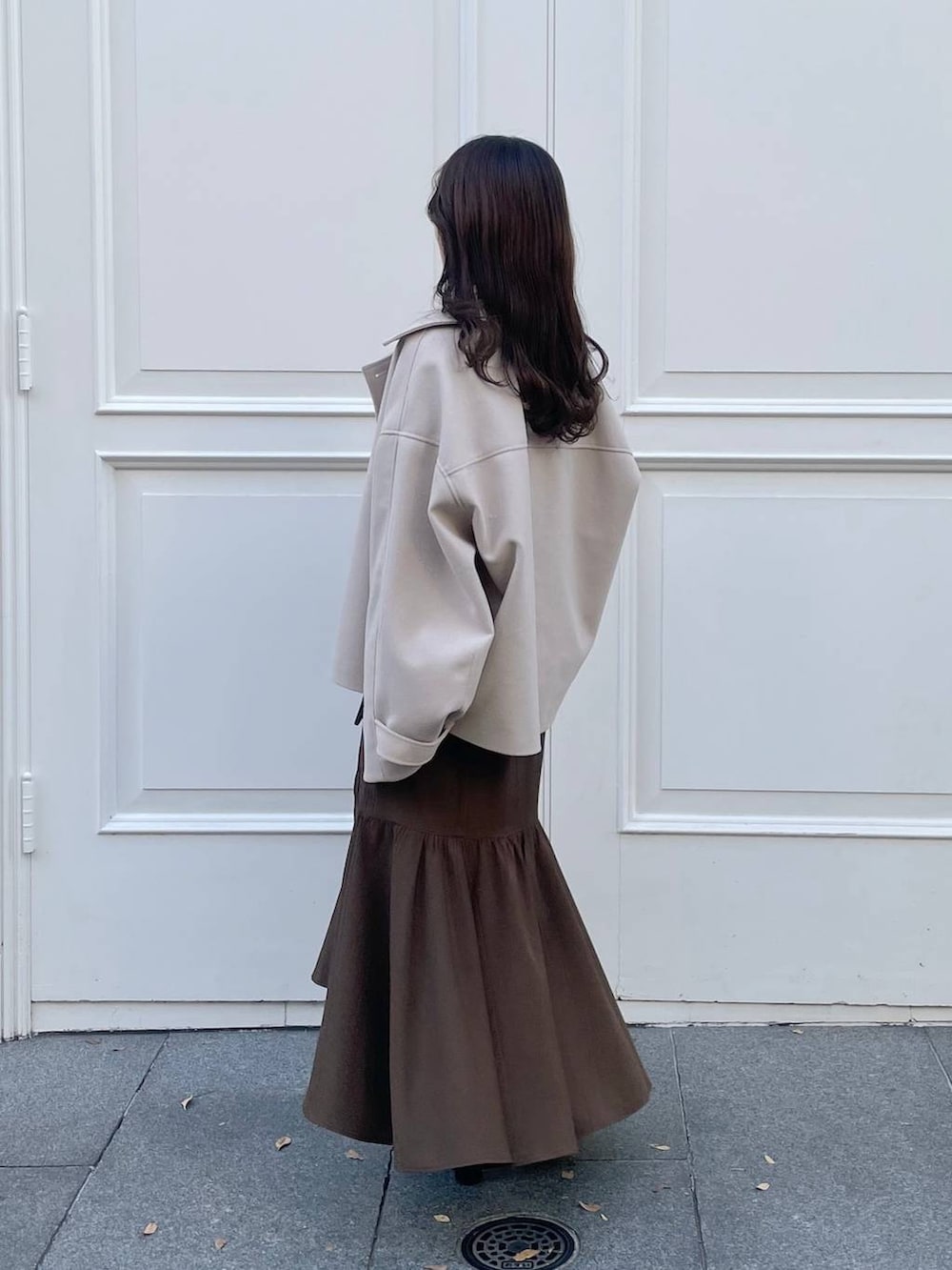 ピンク系のニット/セーター、ホワイト系のその他アウター、ホワイト系のハンドバッグを着用したレディースの秋コーディネートの2枚目の写真