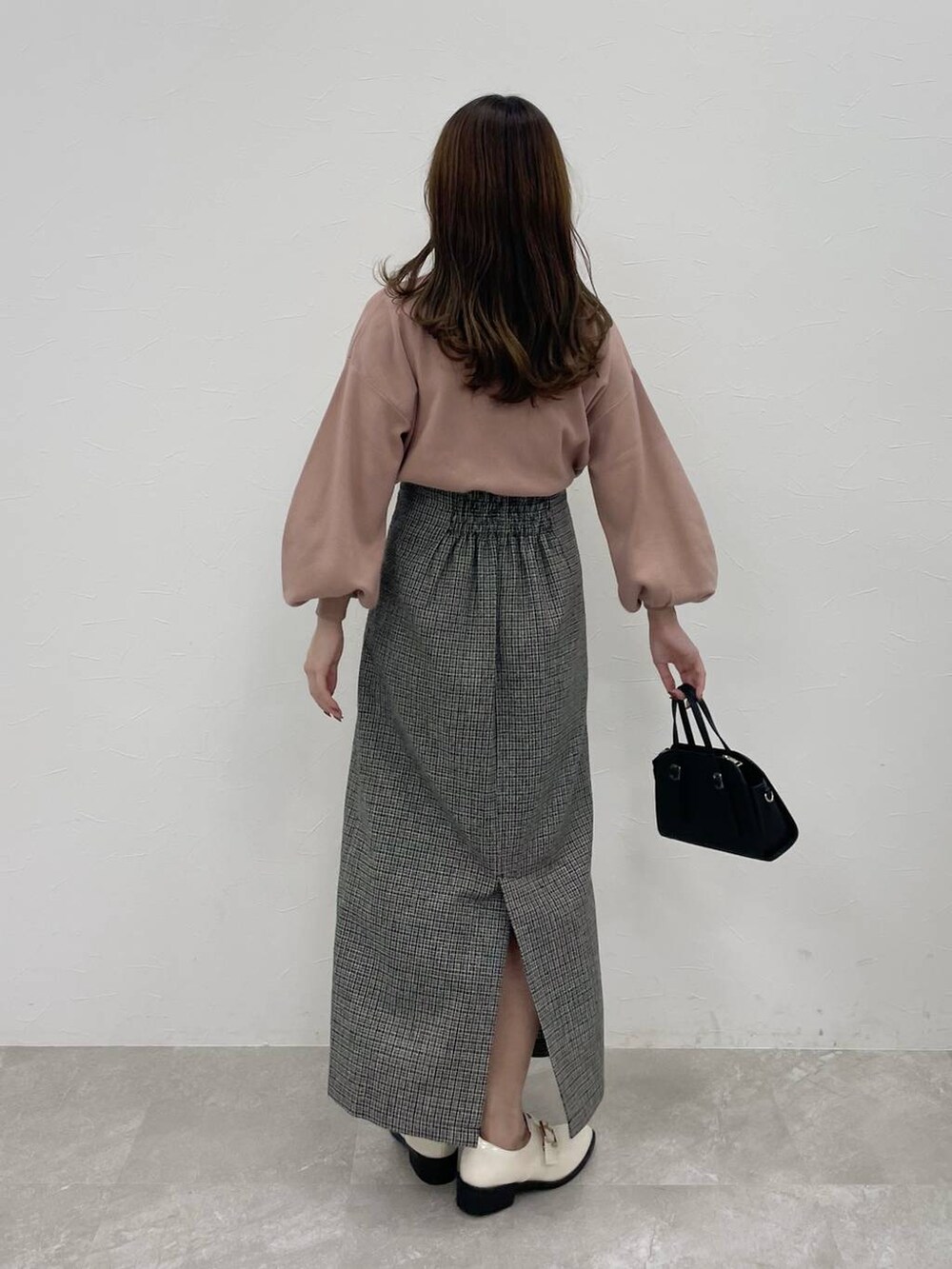 ブラック系のボストンバッグ、ホワイト系のその他シューズ、ピンク系のニット/セーターを着用したレディースの秋コーディネートの5枚目の写真