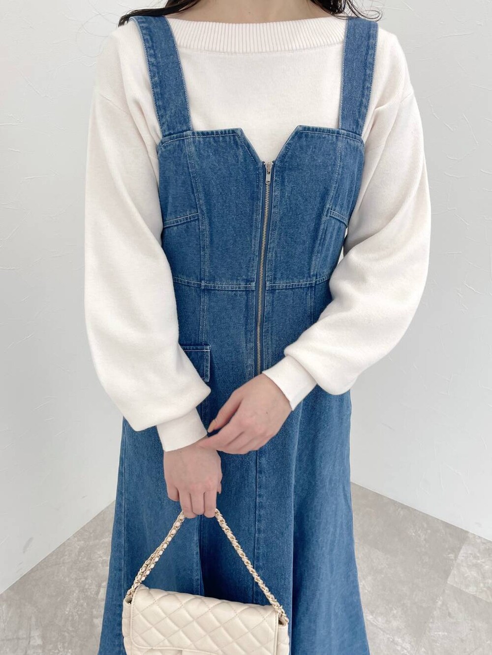 シルバー系のバレエシューズ、ホワイト系のショルダーバッグ、ブルー系のジャンパースカートを着用したレディースの春コーディネートの3枚目の写真