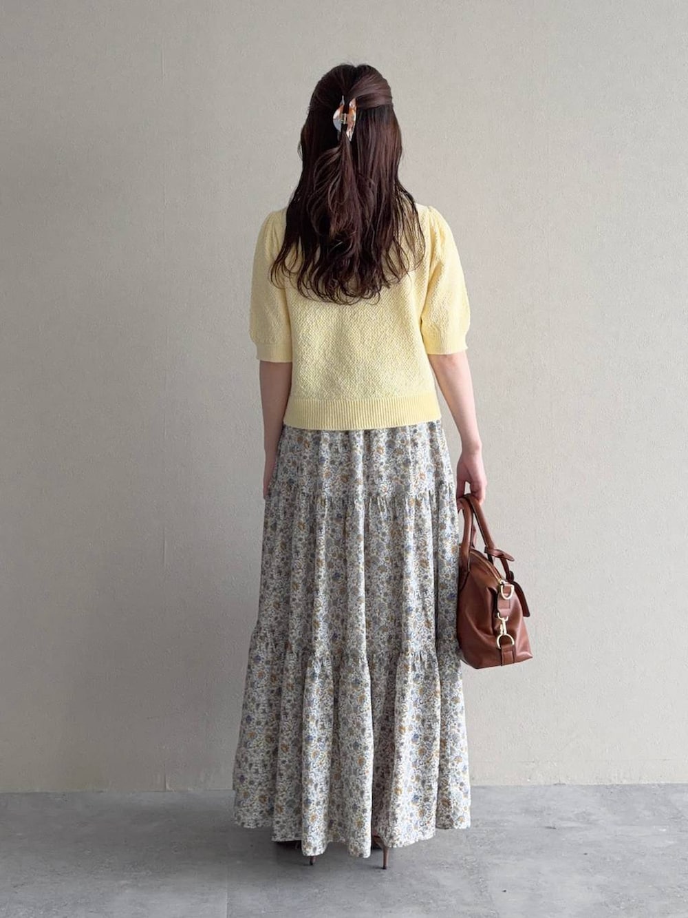 ブラウン系のボストンバッグ、イエロー系のカーディガン/ボレロ、ブラウン系のサンダルを着用したレディースの春コーディネートの2枚目の写真