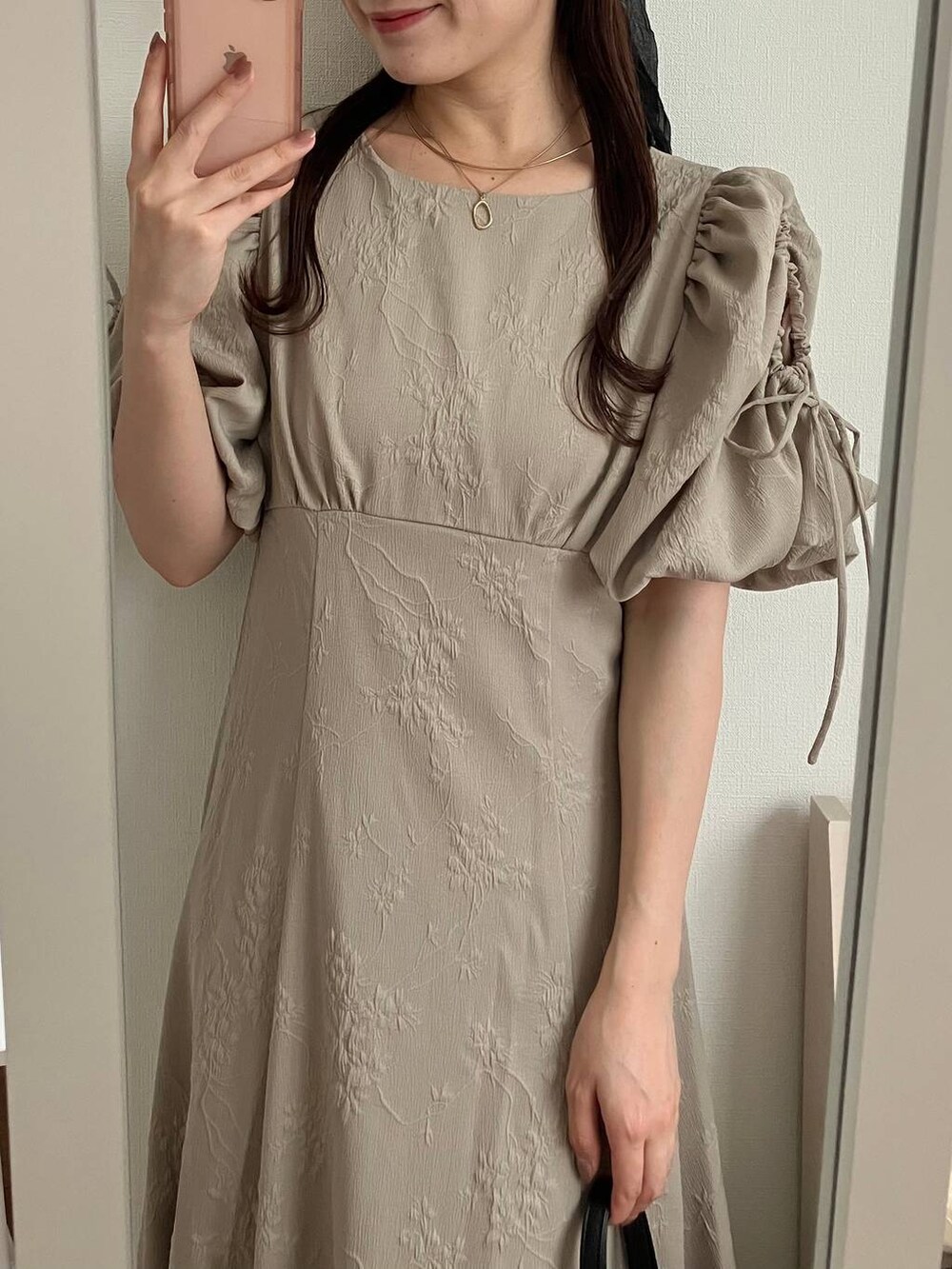 ベージュ系のワンピースを着用したレディースの春コーディネートの3枚目の写真