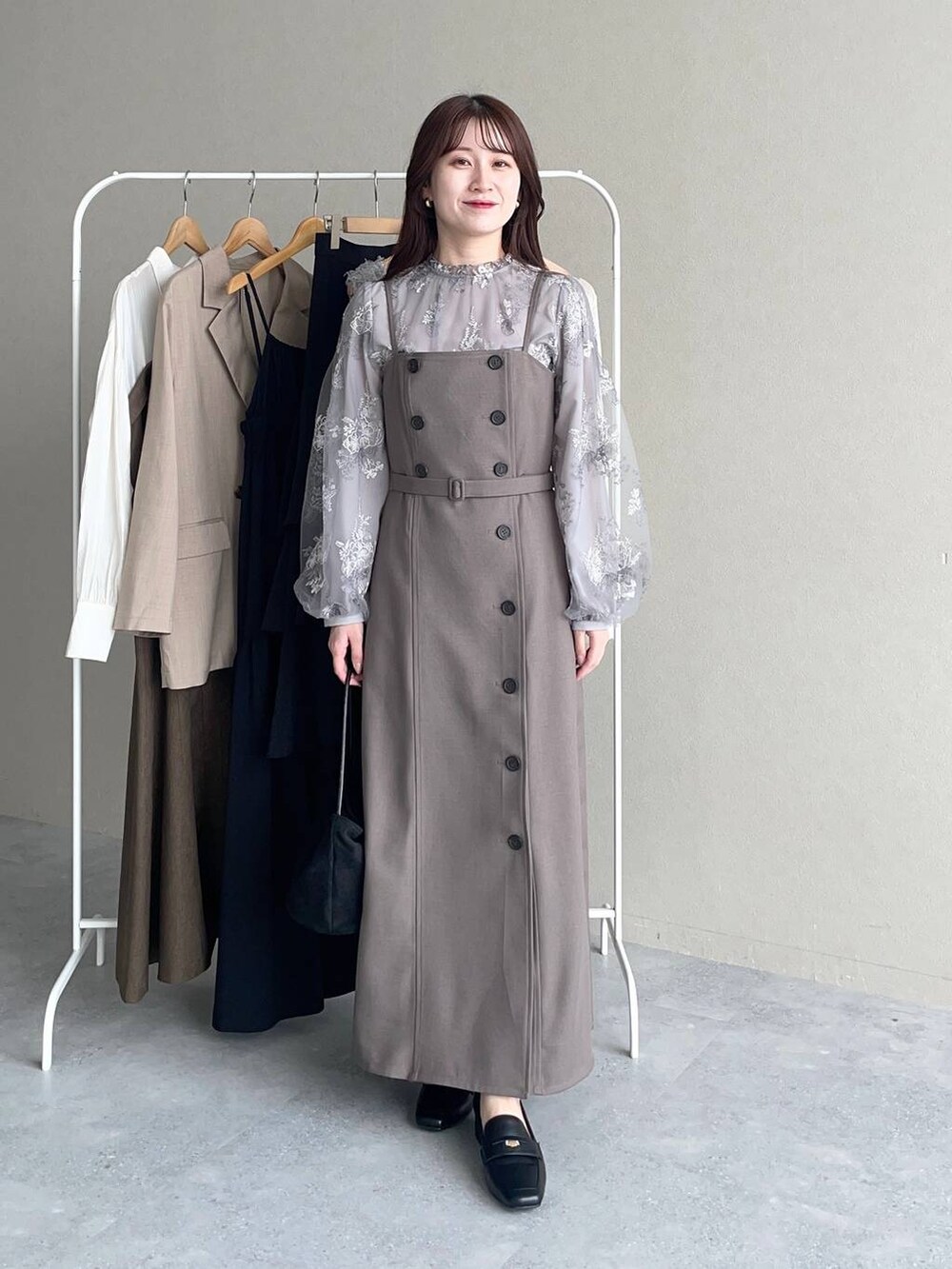 グレー系のシャツ/ブラウス、ベージュ系のワンピース、ブラック系のローファーを着用したレディースの秋コーディネートの3枚目の写真