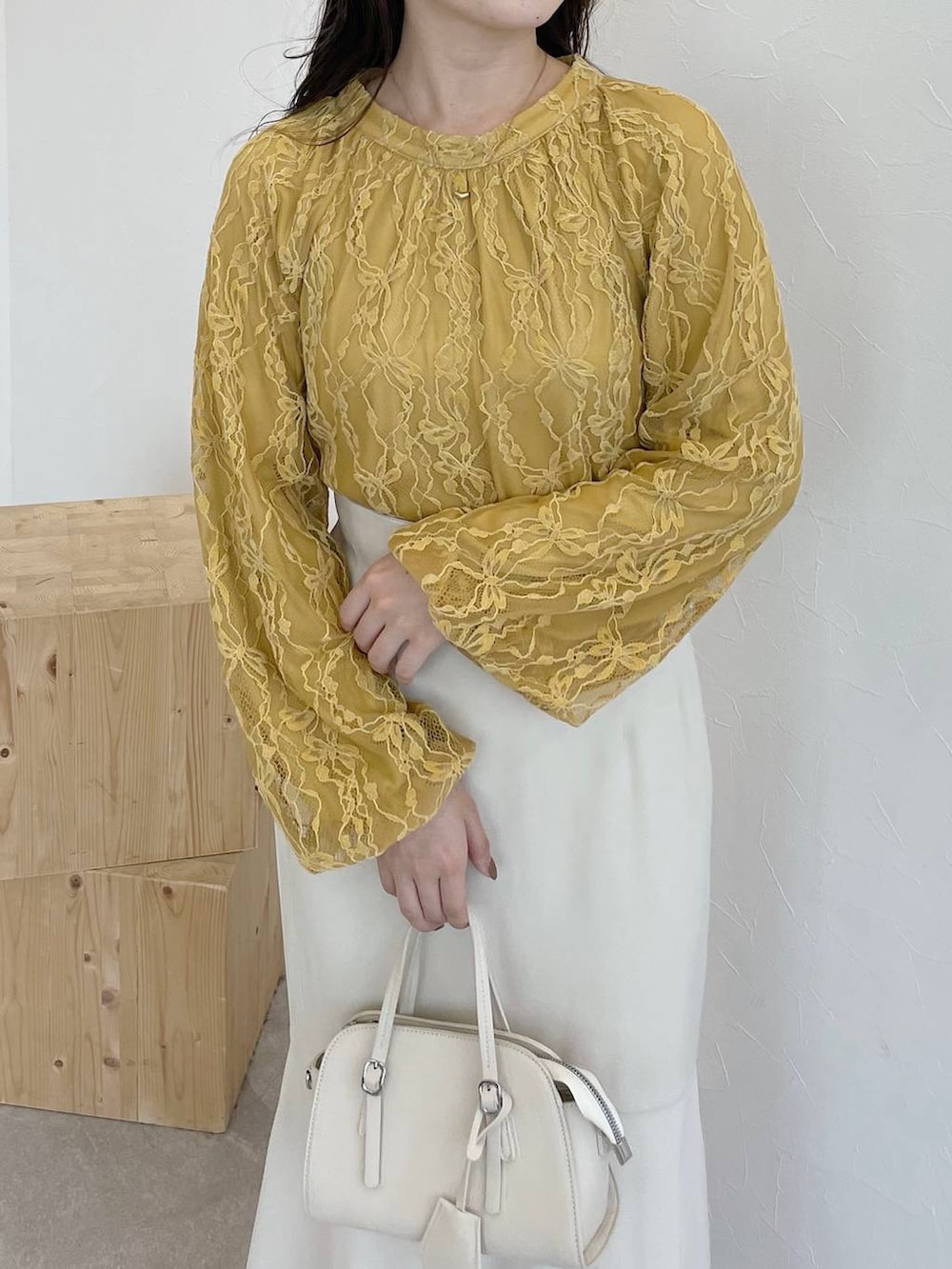 ホワイト系のボストンバッグ、ホワイト系のその他シューズ、イエロー系のシャツ/ブラウスを着用したレディースの夏コーディネートの3枚目の写真