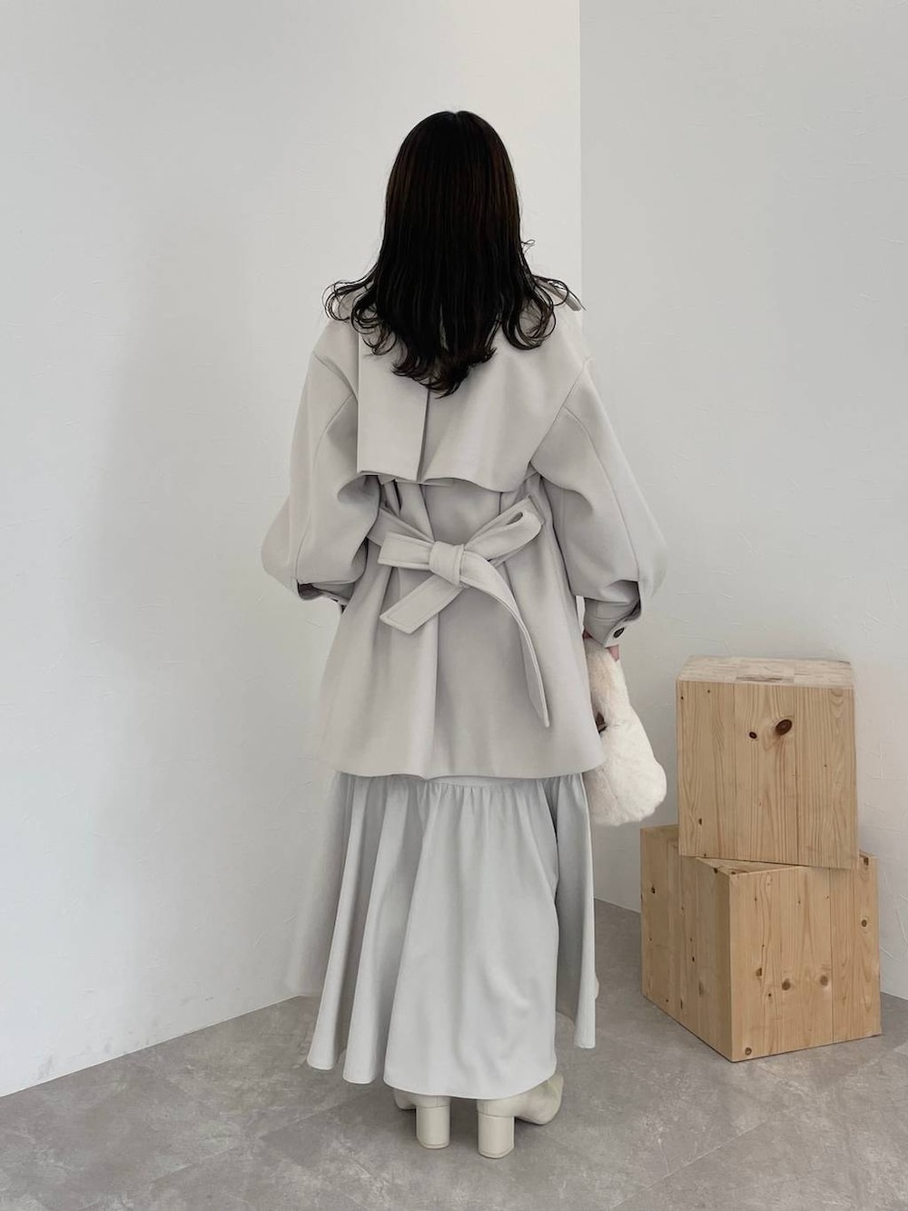 ホワイト系のチェスターコート、ホワイト系のブーツ、ブルー系のシャツ/ブラウスを着用したレディースの秋コーディネートの2枚目の写真