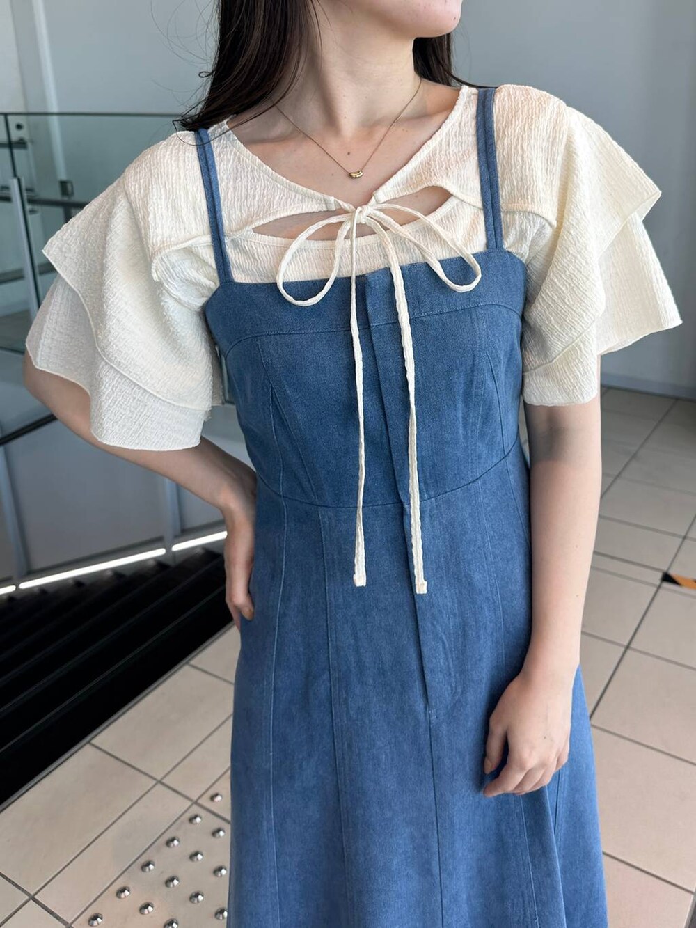 ブルー系のジャンパースカート、ホワイト系のサンダル、ホワイト系のTシャツ/カットソーを着用したレディースの夏コーディネートの3枚目の写真