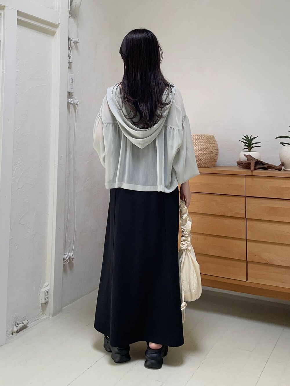 ブラック系のドレス、グリーン系のパーカー、ブラック系のサンダルを着用したレディースの夏コーディネートの2枚目の写真