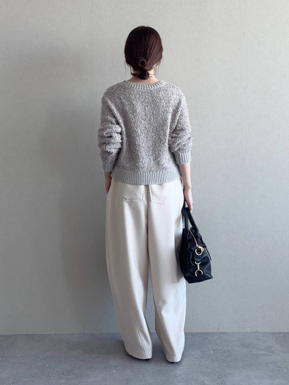 ブラック系のボストンバッグ、ベージュ系のカーディガン/ボレロ、ブラック系のサンダルを着用したレディースの冬コーディネートの2枚目の写真