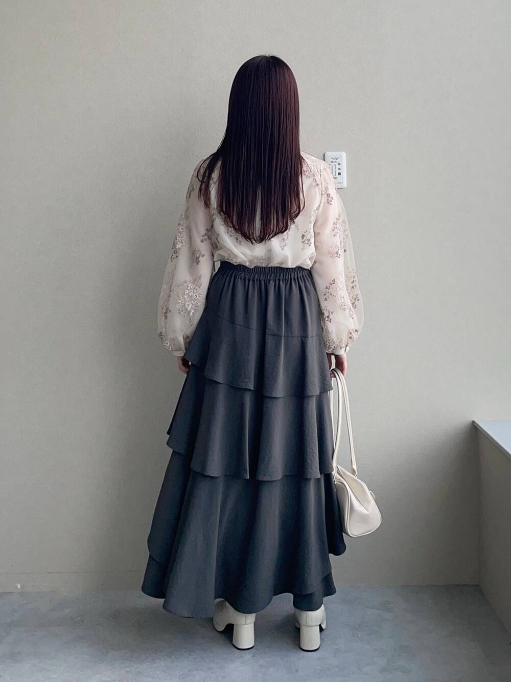 ホワイト系のシャツ/ブラウス、ホワイト系のブーツ、グレー系のスカートを着用したレディースの冬コーディネートの2枚目の写真