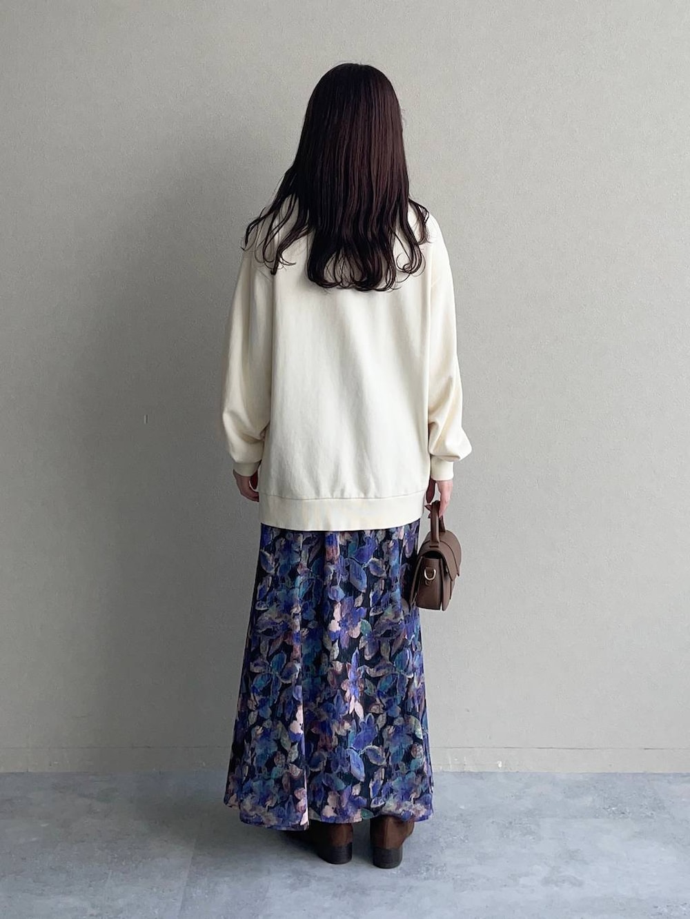 ホワイト系のスウェット、ブラック系のスカート、ブラウン系のローファーを着用したレディースの秋コーディネートの4枚目の写真