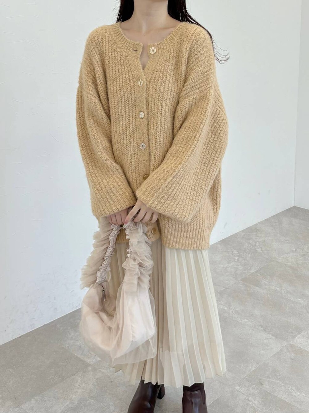 ブラウン系のブーツ、ベージュ系のショルダーバッグ、ベージュ系のカーディガン/ボレロを着用したレディースの冬コーディネートの3枚目の写真