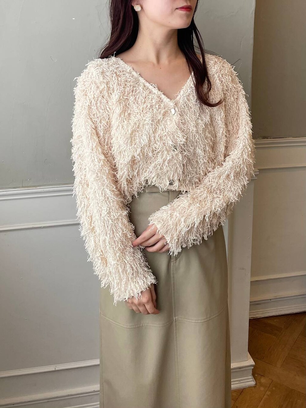 ブラウン系のブーツ、ベージュ系のスカート、ブラウン系のハンドバッグを着用したレディースの冬コーディネートの3枚目の写真