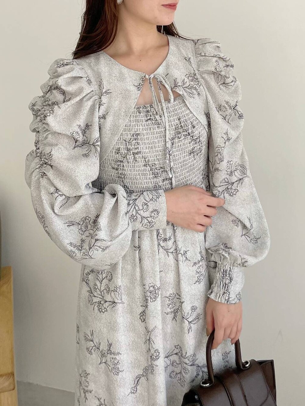 ブラウン系のハンドバッグ、ホワイト系のブーツ、ホワイト系のワンピースを着用したレディースの夏コーディネートの4枚目の写真