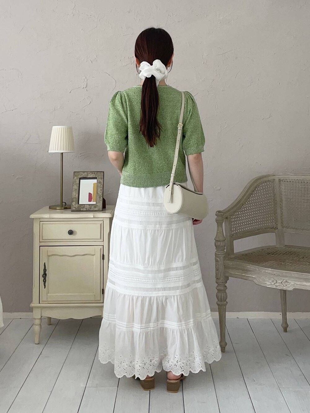 ブラウン系のサンダル、グリーン系のカーディガン/ボレロ、ホワイト系のショルダーバッグを着用したレディースの夏コーディネートの2枚目の写真