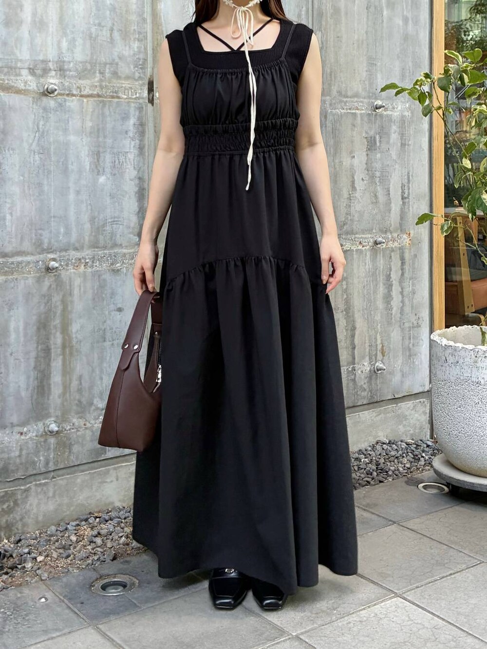 ブラック系のタンクトップ、ブラウン系のショルダーバッグ、ブラック系のワンピースを着用したレディースの夏コーディネートの3枚目の写真